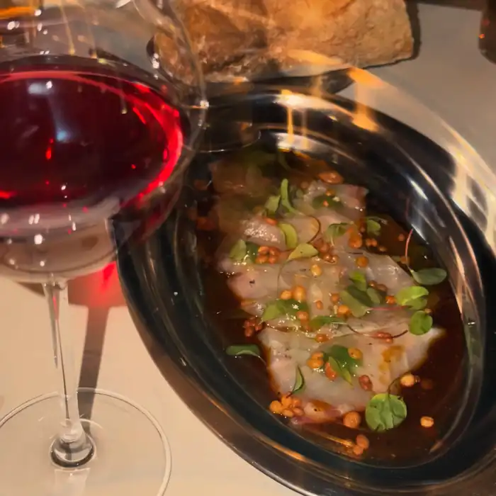Copa de vino tinto junto a un plato